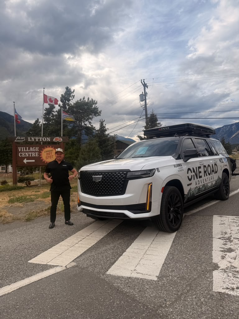 The One Road Adventure vehicle at the Lytton Village Centre sign in British Columbia, Canada.