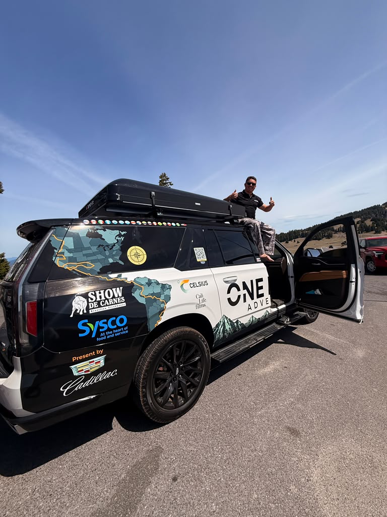The One Road Adventure vehicle parked on a mountain ridge between stops.