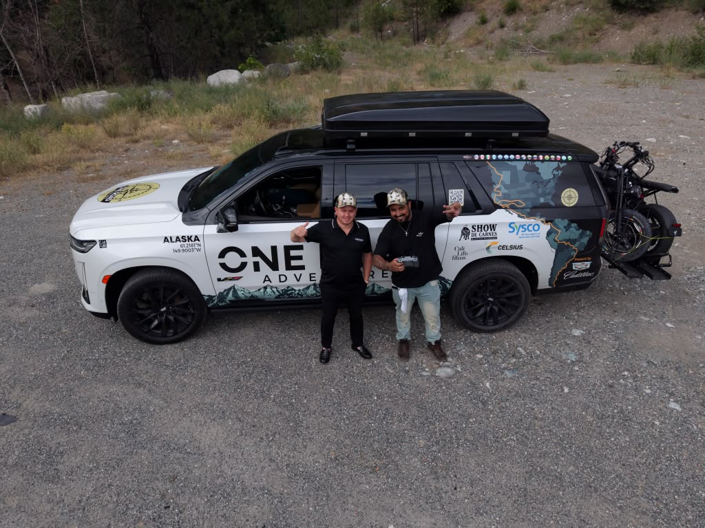 Celso and Fábio beside the One Road Adventure vehicle, with Show de Carnes, Sysco, Cali Life Films and Celsius branding visible.